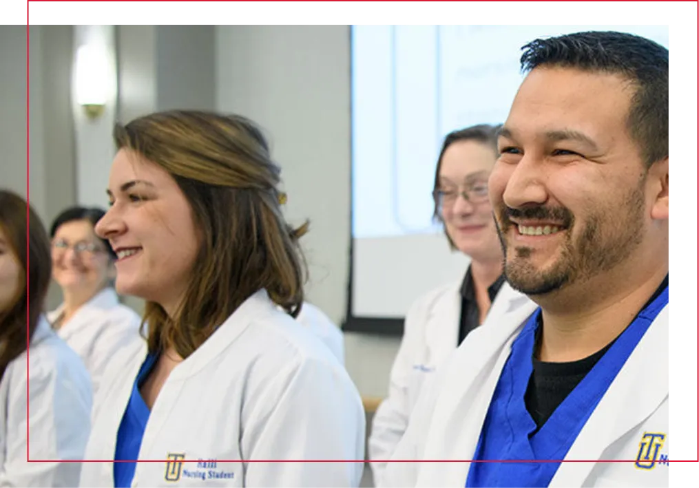 Nursing students in graduation ceremony wearing their whitecoats.