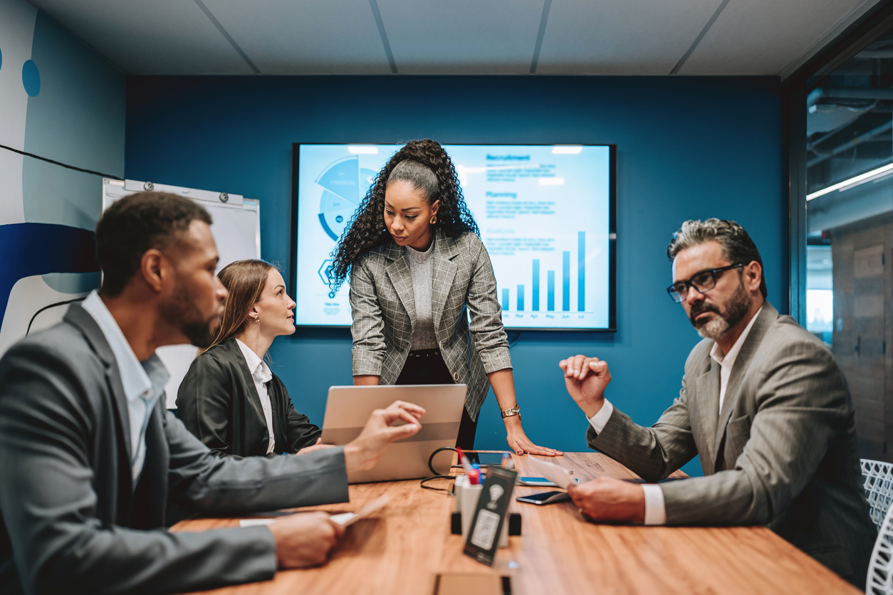 A cybersecurity executive leads a meeting around a conference table.