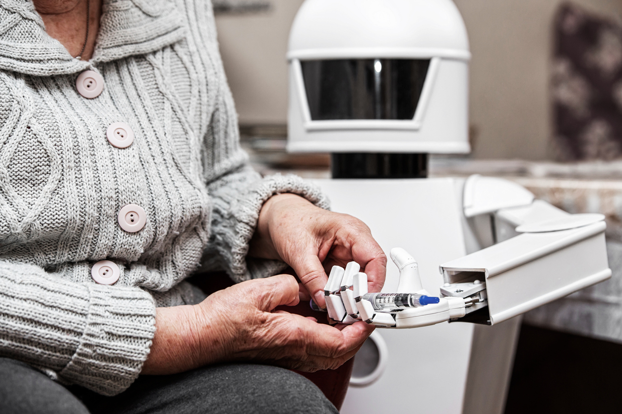 An Older Adult Patient in a Hospital Room With a Health Care Robot Holding a Syringe.