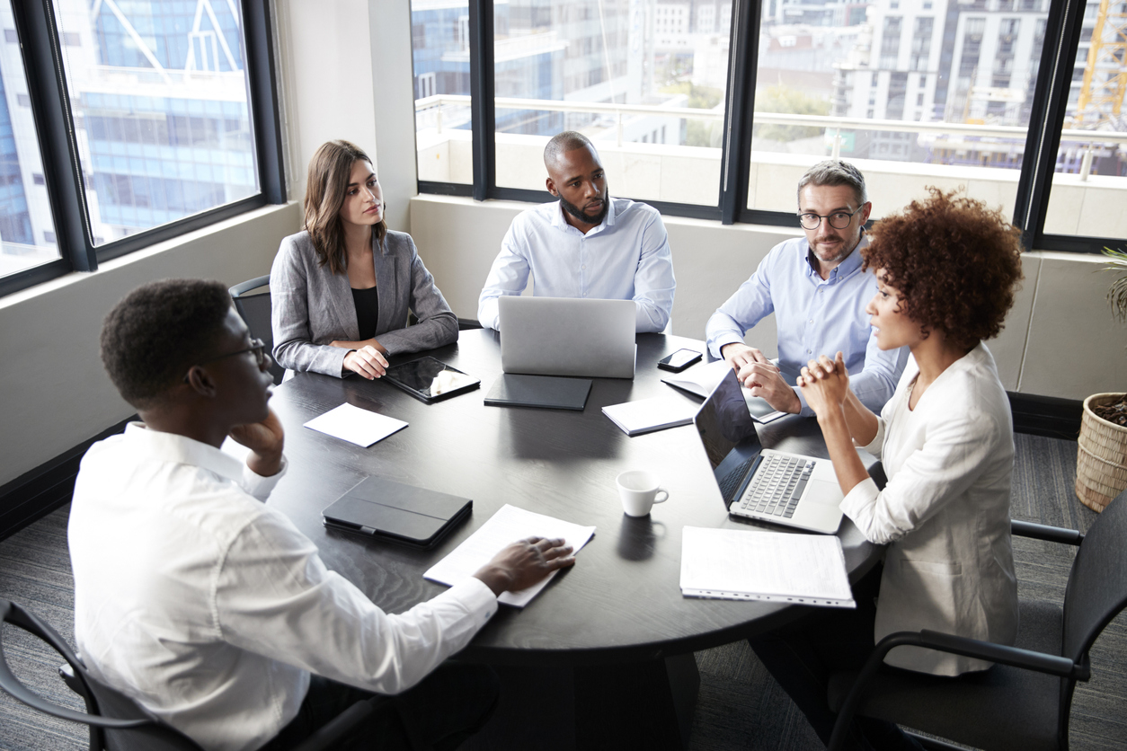 Cybersecurity Professionals Sitting Around a Table in an Office Having a Meeting.