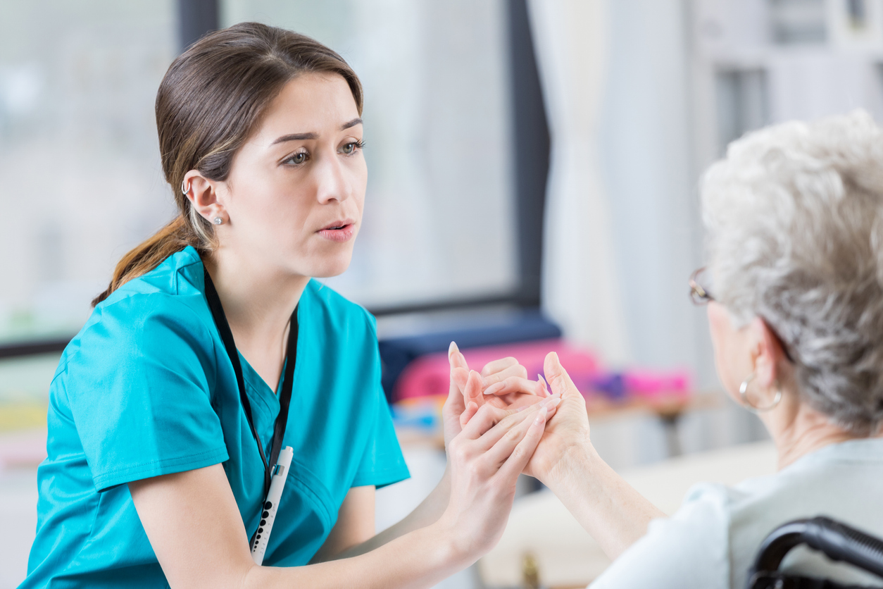  Nurse examining a patient’s hand in a medical facility. 