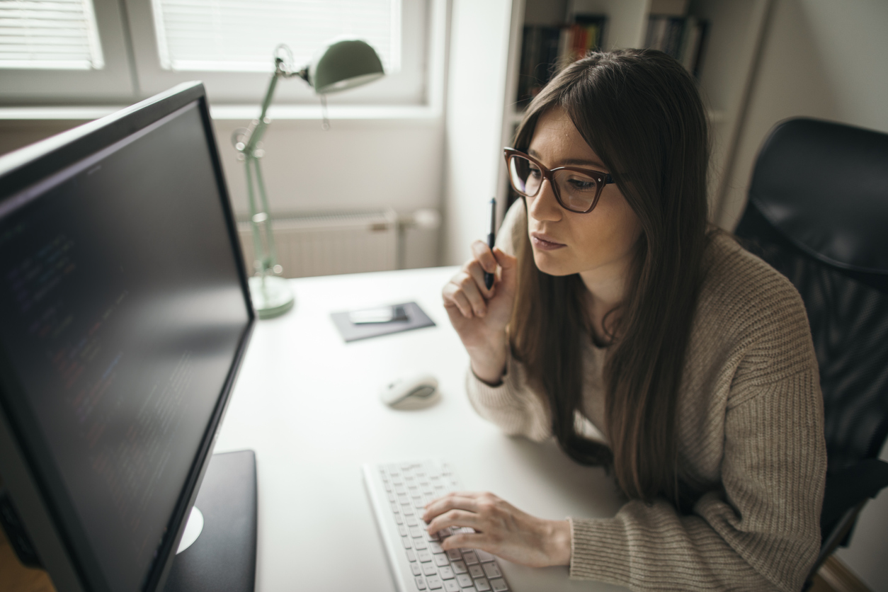 A Cybersecurity Professional Works at a Desk on a Computer.