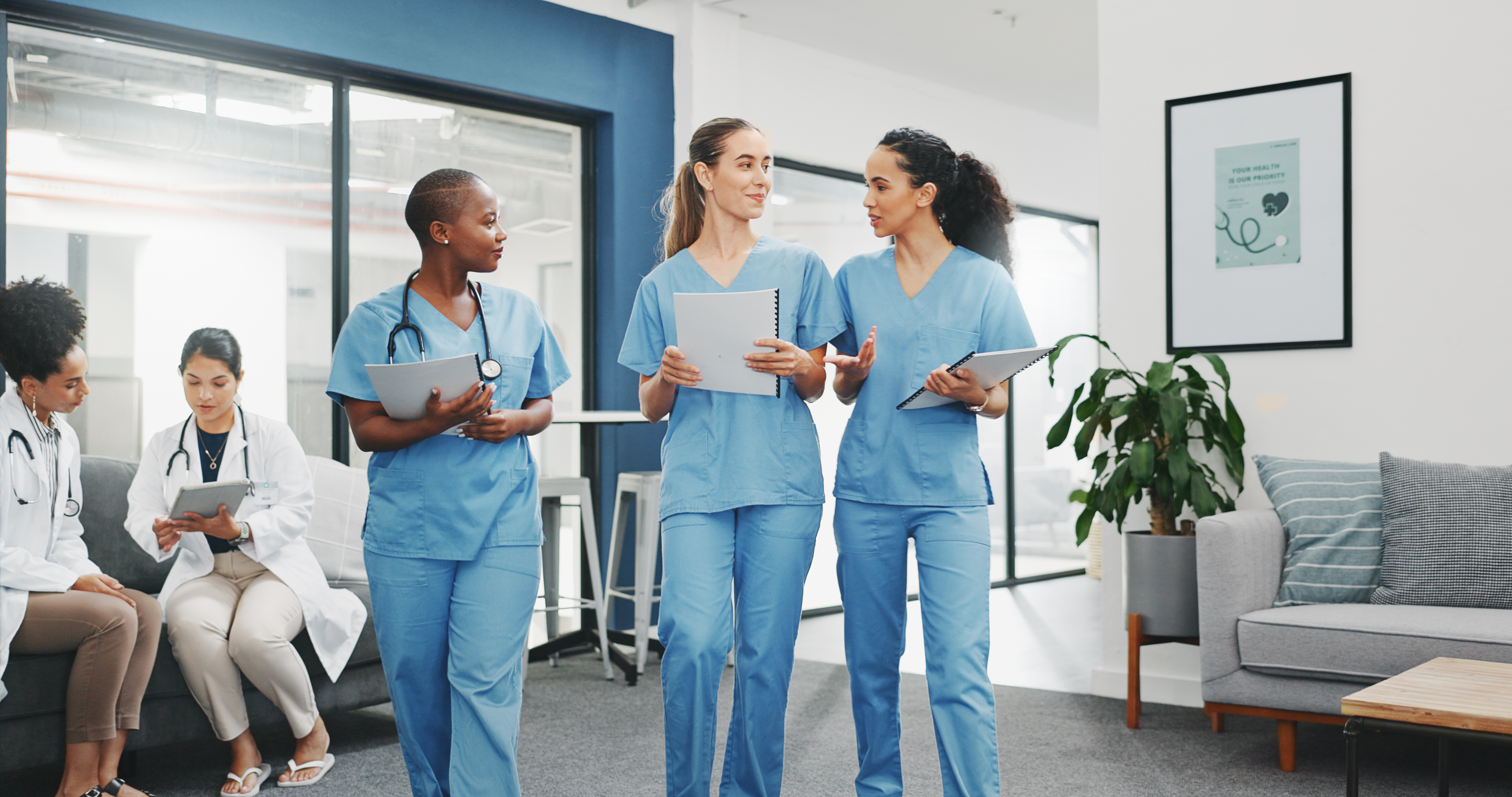 Nurses walking and talking in a medical facility. 